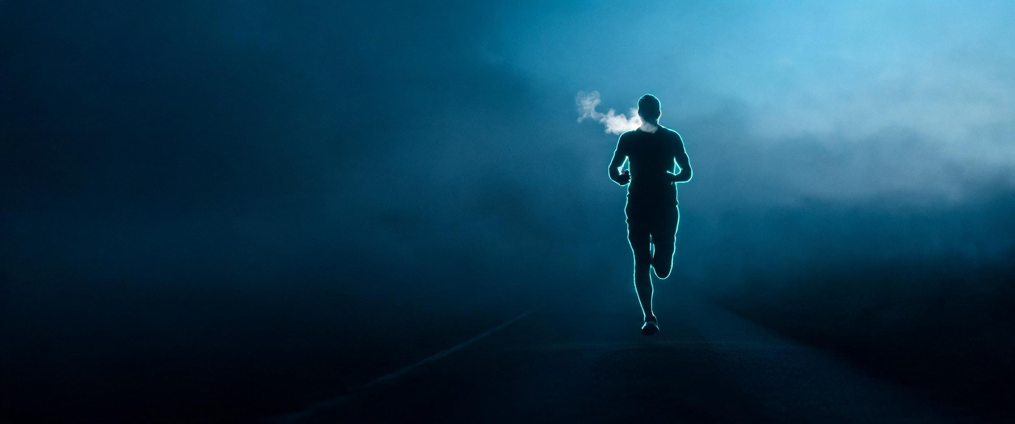 A solo endurance athlete in pre-dawn light, the moment before effort. Forged-metal cinematic tone.